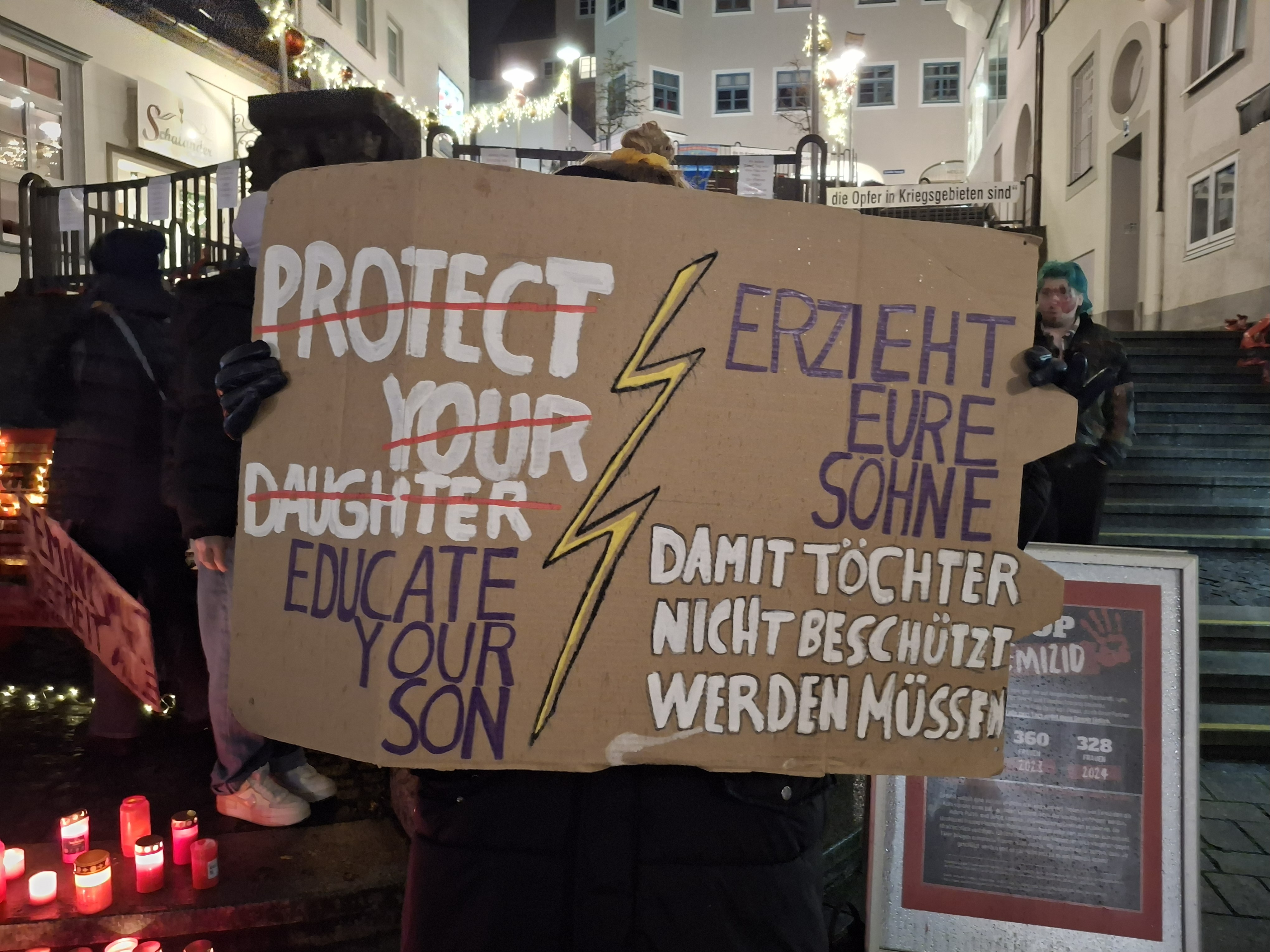 Plakat aus Pappe wird in die Kamera gehalten.