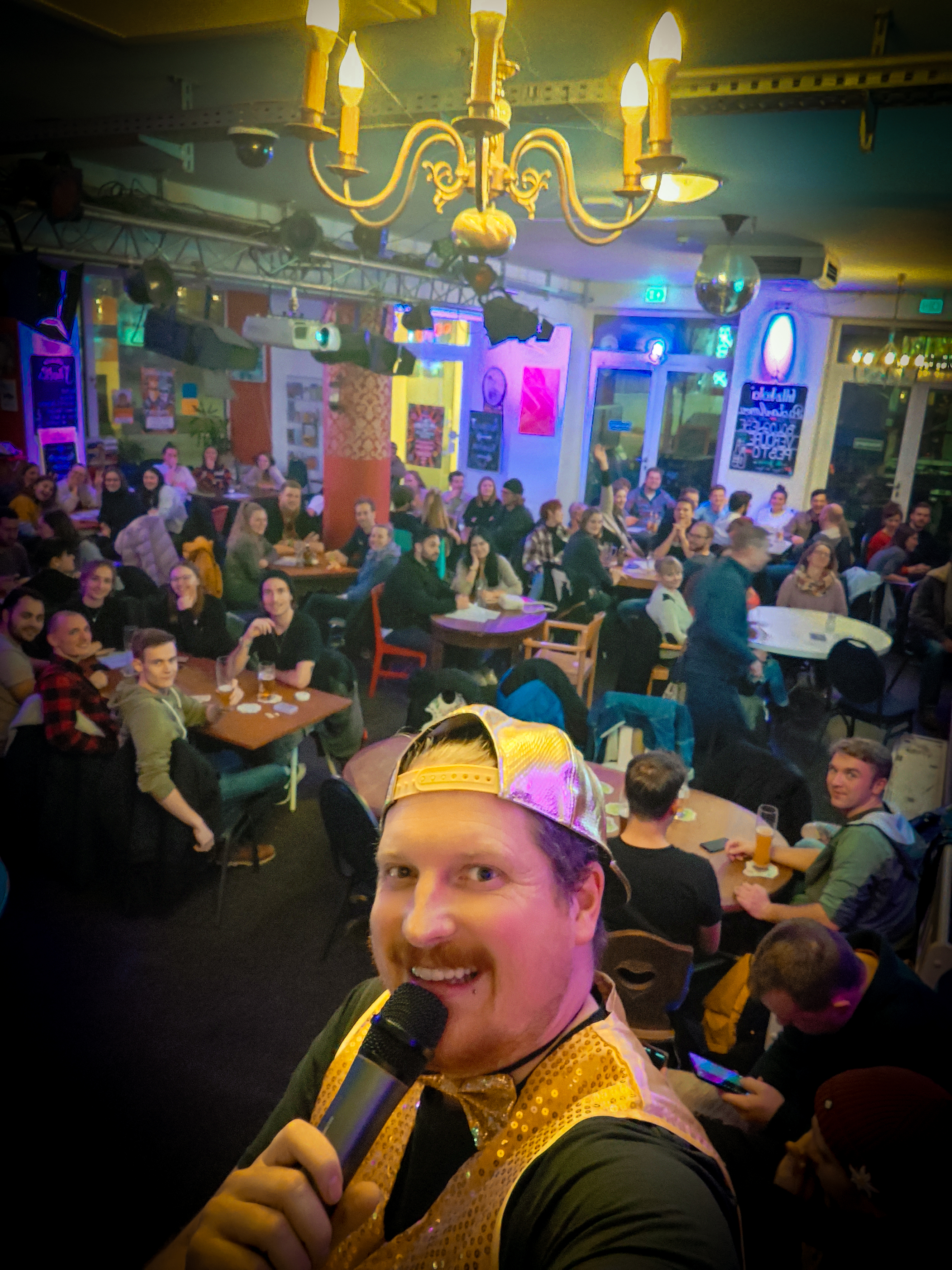 Quizmaster und Gäste mit Blick in die Kamera